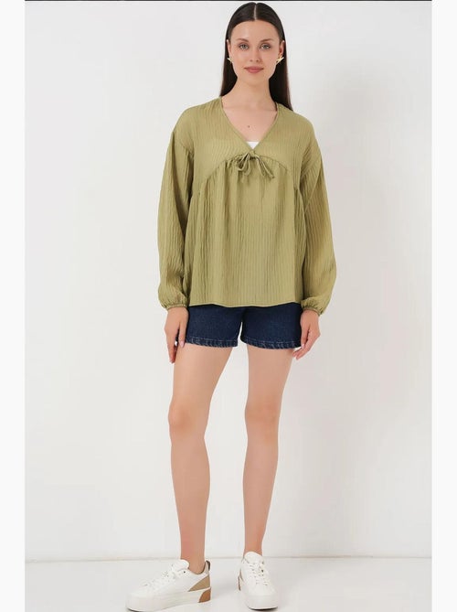 Blusa texturizada seersucker decote em v com laço bdart - Kiabi Blusa texturizada seersucker decote em v com laço bdart - Kiabi