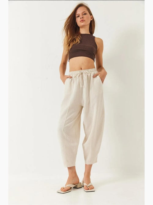 Calça com cintura elástica e virilha descaída com detalhe de bolso lucci - Kiabi Calça com cintura elástica e virilha descaída com detalhe de bolso lucci - Kiabi