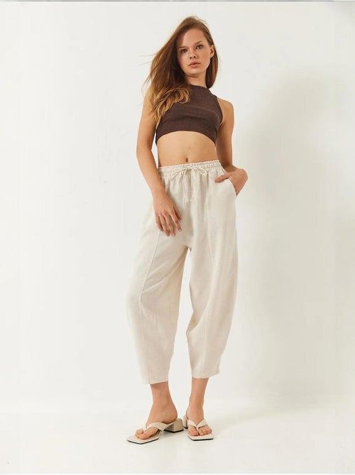 Calça com cintura elástica e virilha descaída com detalhe de bolso lucci - Kiabi Calça com cintura elástica e virilha descaída com detalhe de bolso lucci - Kiabi