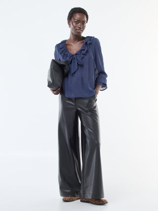 Calças largas em imitação de pele lisa