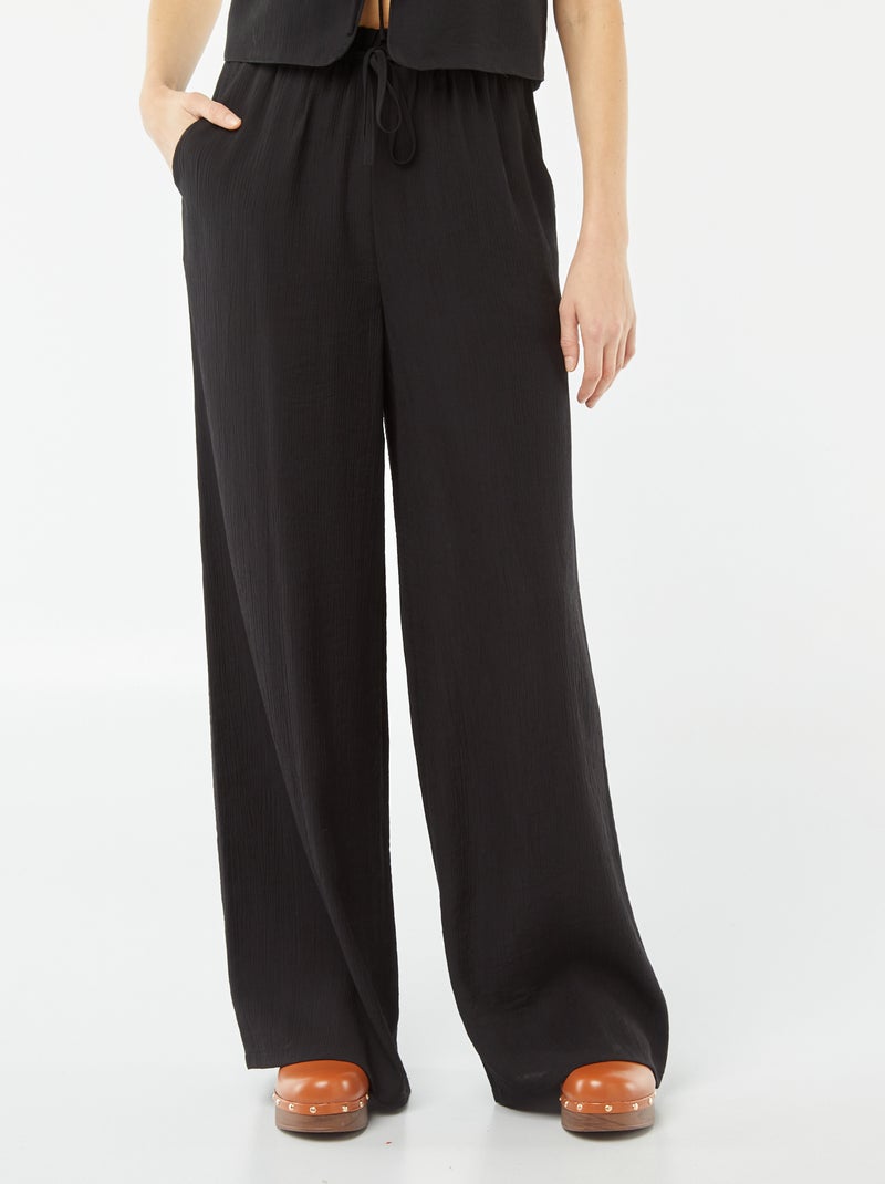 Calças largas em material crepe com 2 bolsos Preto - Kiabi