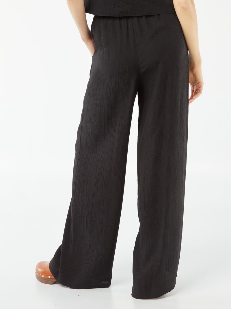 Calças largas em material crepe com 2 bolsos Preto - Kiabi