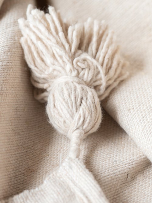 Cama de lã com borlas - Kiabi Cama de lã com borlas - Kiabi