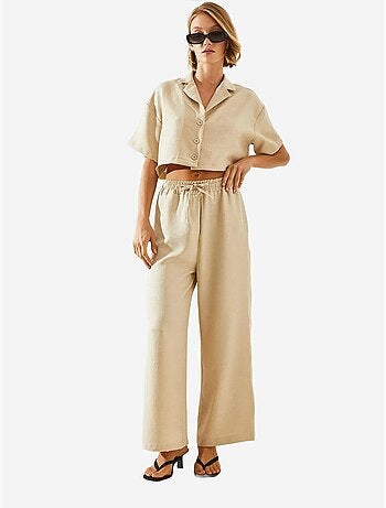 Conjunto de duas peças com blusa cropped e calças abotoadas e bolsos lucci
