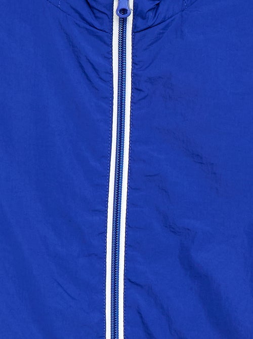 Corta-vento liso que se guarda no capuz - Kiabi