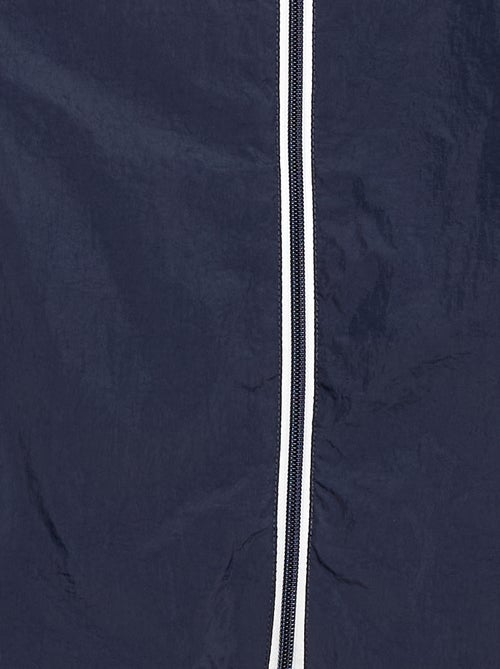 Corta-vento liso que se guarda no capuz - Kiabi