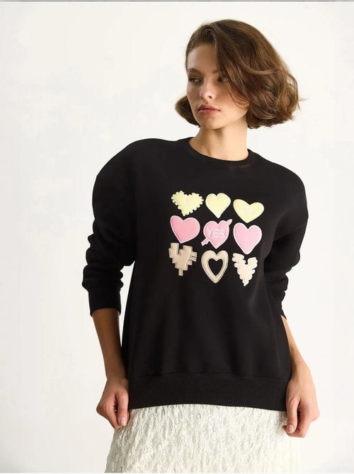 Sweatshirt de gola redonda de corte descontraído com aplicações de patches de coração lucci - Kiabi Sweatshirt de gola redonda de corte descontraído com aplicações de patches de coração lucci - Kiabi