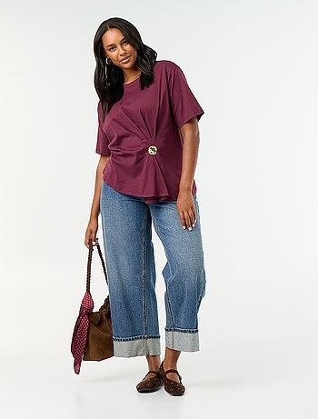 T-shirt drapeada com joia dourada tipo broche