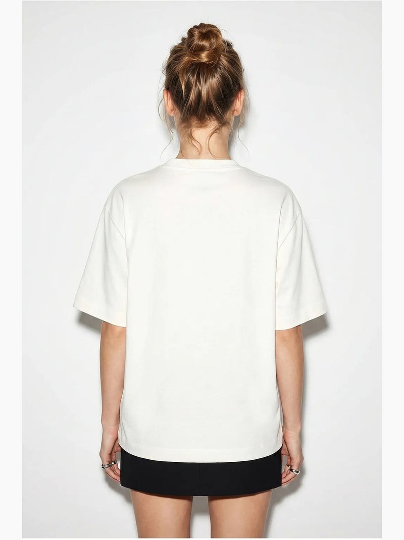 T-shirt feminina de algodão com decote barco e estampado lucci Branco sujo - Kiabi